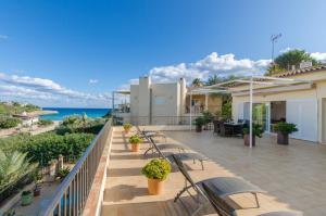 a balcony with chairs and a view of the ocean at Bexan Cala Mandia in Cala Mendia