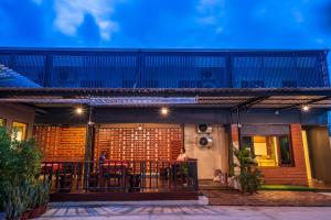 a house with a patio with tables and chairs at The Sekret Hotel in Sungai Kolok
