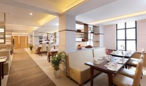 a restaurant with tables and chairs and a bar at Flora Charishma Residency Aluva in Cochin