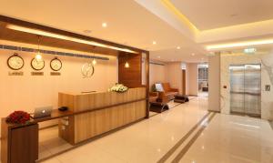 a lobby of a hospital with a reception desk and clocks at Flora Charishma Residency Aluva in Cochin