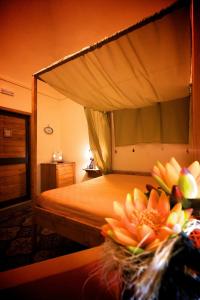 a bedroom with a canopy bed with a flower on a table at Olympo in Bisceglie