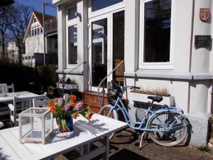 ein Fahrrad neben einem Haus mit einem Tisch mit Blumen geparkt in der Unterkunft Villa Möwenstein in Timmendorfer Strand