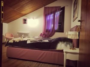 a bedroom with a bed and a window with purple curtains at Tenuta I Ginepri in Ozzano dell Emilia +11 photos