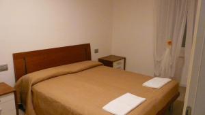 1 dormitorio con 1 cama y 2 toallas blancas en Cinzia Dolomiti del Brenta, en Tassullo