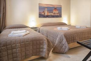een hotelkamer met twee bedden en een foto aan de muur bij 43 Palazzuolo House by 360Rentals in Florence