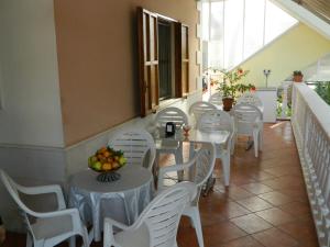 馬薩夫拉的住宿－Villa Robinia，一间设有白色桌子和白色椅子的餐厅
