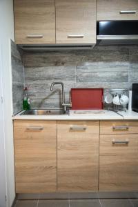 a kitchen with wooden cabinets and a sink at Diamerisma-Grafeio in Piraeus