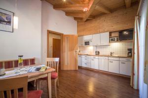 uma cozinha com armários brancos e uma mesa de madeira em Villa Amsel em Mayrhofen