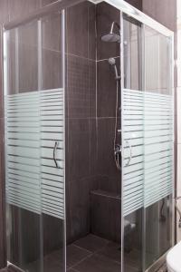 W łazience znajduje się prysznic ze szklanymi drzwiami. w obiekcie Dimitras Apartment w Atenach