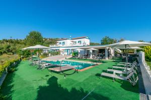 una piscina con sedie a sdraio e ombrelloni di Akis Villa Studios & Apartment with Pool by Hotelius ad Agios Georgios Pagon