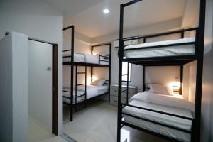 Pokój z 3 łóżkami piętrowymi i lustrem w obiekcie Tall Tree Kata Phuket w mieście Kata Beach