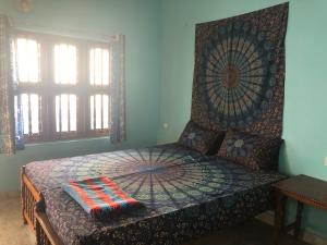 a bedroom with a bed with a patterned head board at Zen House in Kovalam