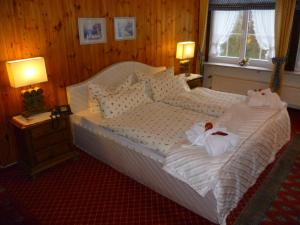 a bedroom with a bed with two stuffed animals on it at Wellness und Romantik Hotel Helmboldt in Bad Sachsa