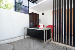 un bureau avec un bureau et une chaise rouge dans l'établissement Super OYO 1565 Palebon Residence, à Semarang