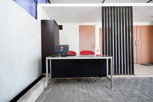 an office with a desk with a laptop on it at Super OYO 1565 Palebon Residence in Semarang