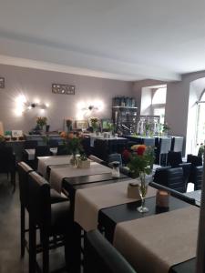 restauracja ze stołami i krzesłami z kwiatami w obiekcie Appart'Hôtel Les Tilleuls w mieście Saint-Macaire