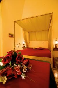 a bedroom with a bed with roses on a table at Olympo in Bisceglie