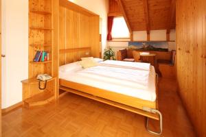 a bedroom with a bed and a book shelf at Residence Rose in San Candido