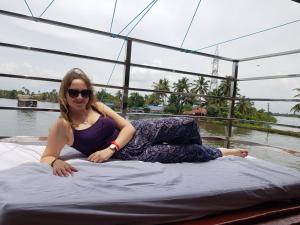 a woman laying on a bed on a boat at Vaishnav Tours in Alleppey