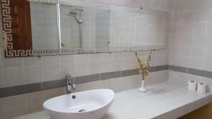 a bathroom with a white sink and a shower at Annexe de l'Hotel de la Poste in Diego Suarez