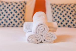 a stack of towels sitting on a bed at Apartments WS - Haut-Marais - Carreau du Temple in Paris
