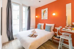 a room with a bed with an orange wall at Apartments WS - Haut-Marais - Carreau du Temple in Paris