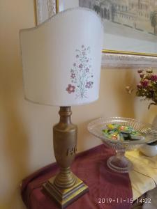 una lampada su un tavolo accanto a un cesto di frutta di Hotel del Centro a Palermo