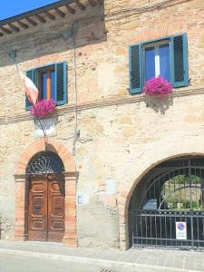 a building with two windows and a door and flowers at Le Rondini in Petrignano