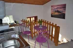 a kitchen with purple chairs and a table in a kitchen at studio indépendant dans maison à la campagne in Égliseneuve-près-Billom