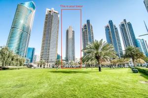 a park in front of a city with tall buildings at Quintessential Quarters - Ultra-modern and Spacious Aparment in Dubai