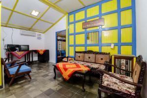 a room with a table and chairs and a tv at Homestay Ndalem Soewondo in Yogyakarta