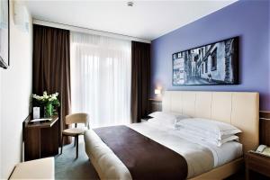una camera con un grande letto e una parete blu di Hotel Raffaello a Firenze