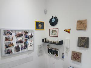 una pared blanca con un reloj y fotos en ella en Buonaluna B&B, en Palermo