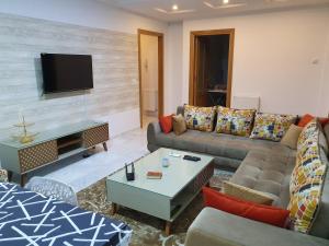 a living room with a couch and a tv at Luxury and Splendid 2 Bedrooms Apartment in Jardin De Carthage Tunis in Tunis
