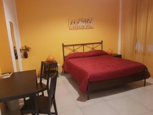 1 dormitorio con 1 cama con manta roja y escritorio en Buonaluna B&B, en Palermo