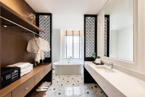 a bathroom with a large mirror and a large tub at One Patio Hotel Pattaya - SHA Extra Plus in Pattaya Central
