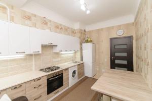 a kitchen with white cabinets and a stove top oven at Apartment deluxe in Chişinău