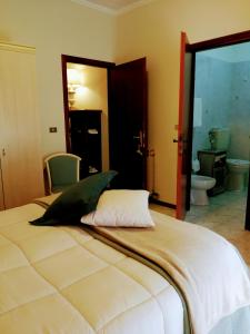 アックイ・テルメにあるAlbergo Nuovo Gianduiaのバスルーム付きの客室の大型ベッド1台分です。