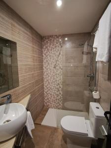 a bathroom with a toilet and a sink and a shower at Hotel Restaurante Las Galias in Zuera