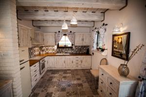 a kitchen with white cabinets and a tile floor at Chata Provence in Mýto pod Ďumbierom