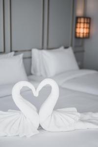 two white swans forming a heart on a bed at The Wing Boutique Hotel in Chiang Mai