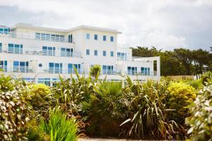 a white building with blue windows and plants at St Moritz Hotel and Cowshed Spa in Polzeath