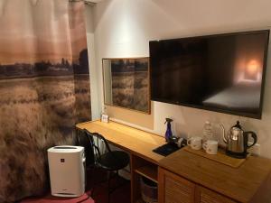 a desk with a large television on a wall at The Wall Hotel in Osaka