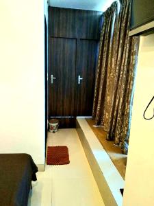 塔那的住宿－Hotel Shambuji，一间设有门和窗帘的卧室