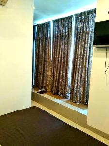 a room with a window with brown curtains at Hotel Shambuji in Thane