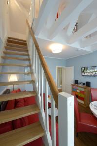 - un salon avec des escaliers et une chaise rouge dans l'établissement Strandhafer, à Boltenhagen