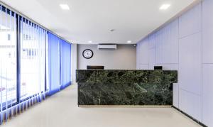 un ufficio con un bancone con un orologio sul muro di Treebo Trend Arna Residency a Guwahati