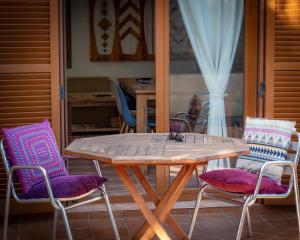 une table et des chaises en bois sur une terrasse dans l'établissement Casa Silencio, Villa with terrace, garden and large pool area, à Corralejo