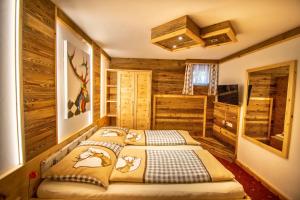 Sankt Martin am GrimmingにあるVilla Salzaの木製の壁のベッドルーム1室(ベッド2台付)