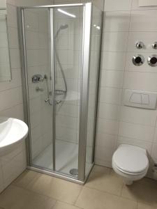 a bathroom with a shower with a toilet and a sink at Comfort Boardinghouse in Kornwestheim